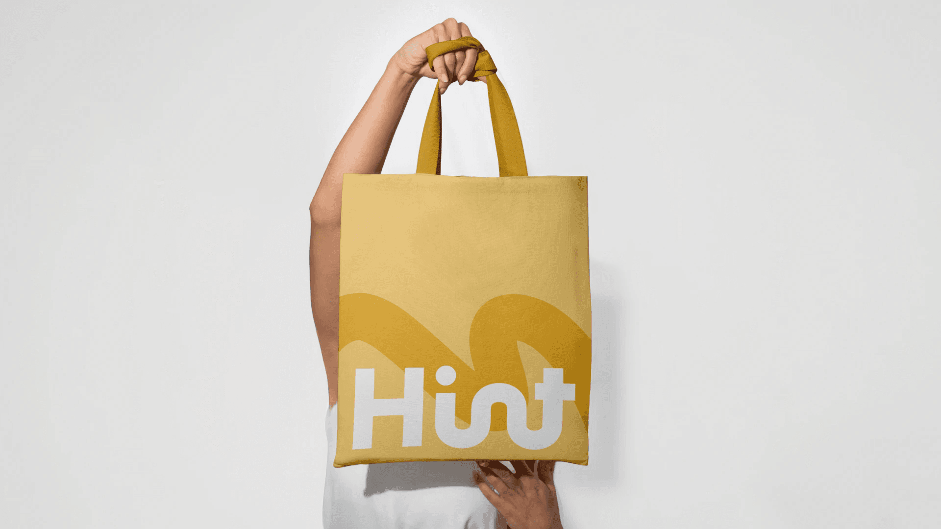 Brand exploration 3.0: a yellow tote bag with the looping wordmark