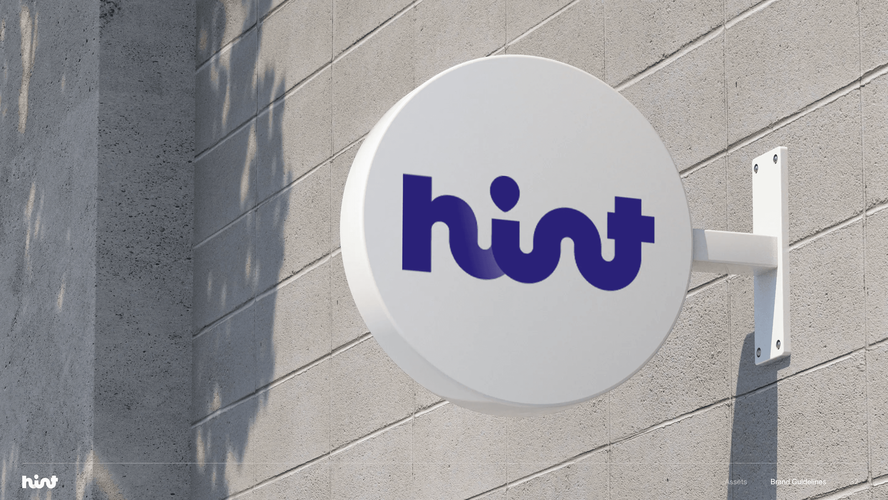 Hint brand guide: a round Hint shop sign mounted on a concrete wall