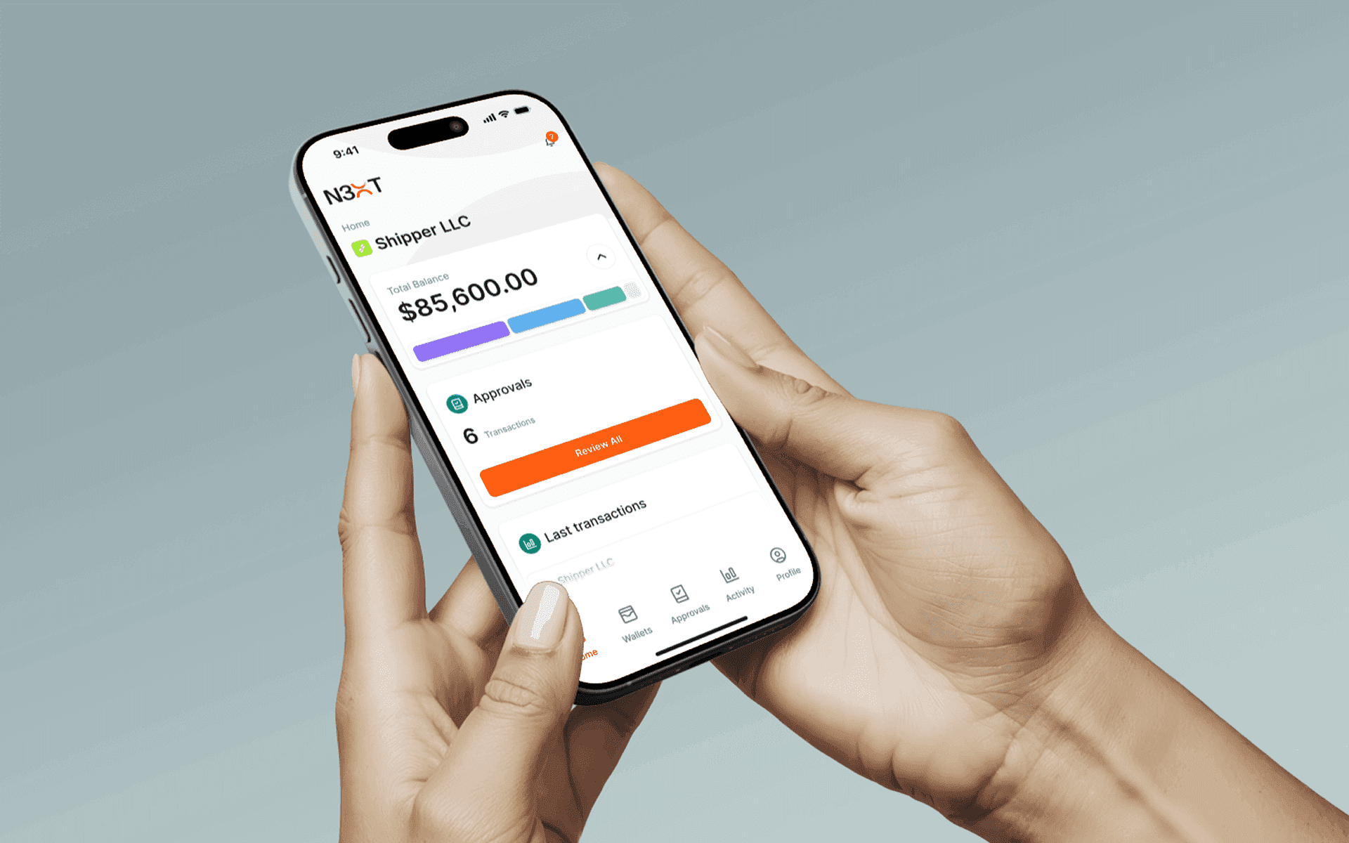 Hand holding a phone showing the N3XT dashboard